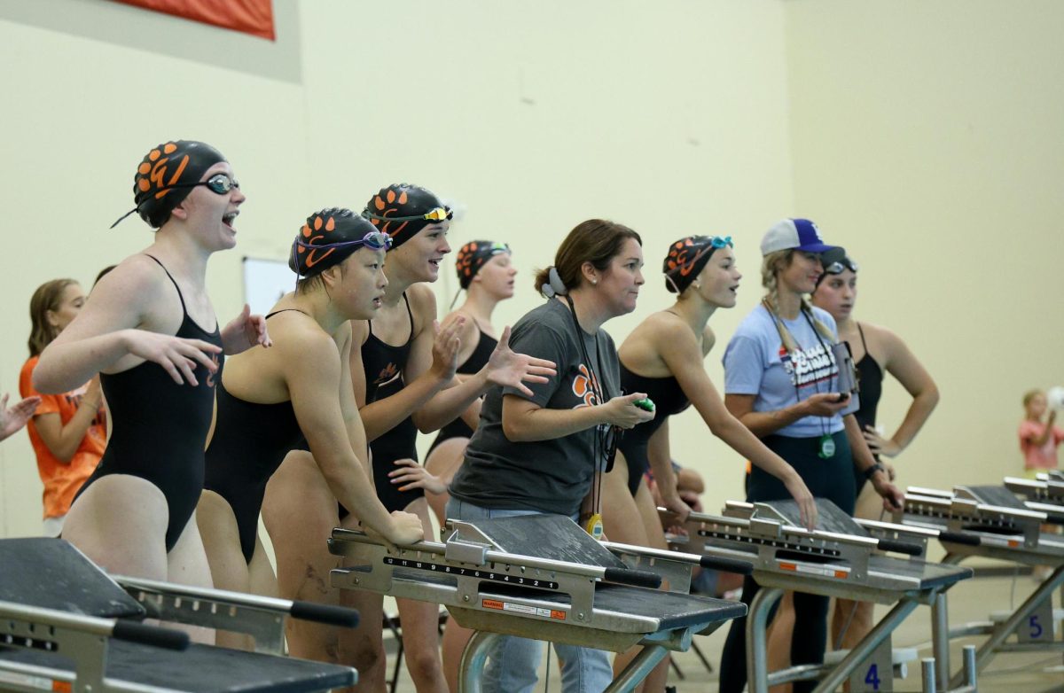 Girls swimmers cheer on their teammates during an intersquad meet Aug. 31.