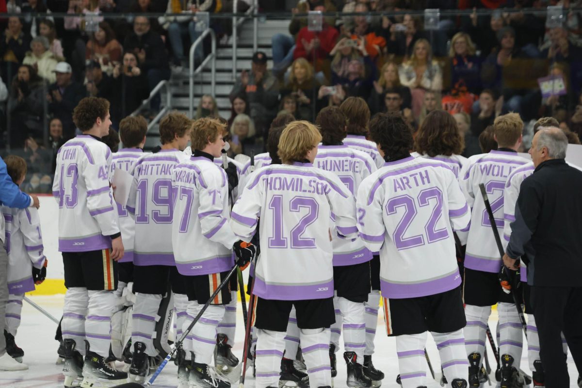 EHS's varsity hockey team poses for a group picture in their "Hockey Fights Cancer" jerseys during the game on Oct. 18.