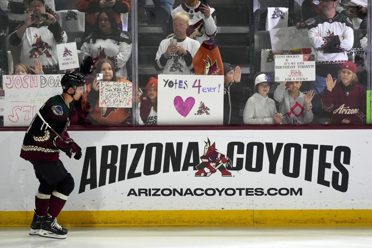 Arizona Coyotes hold signs during the team's last ever home game in Arizona.