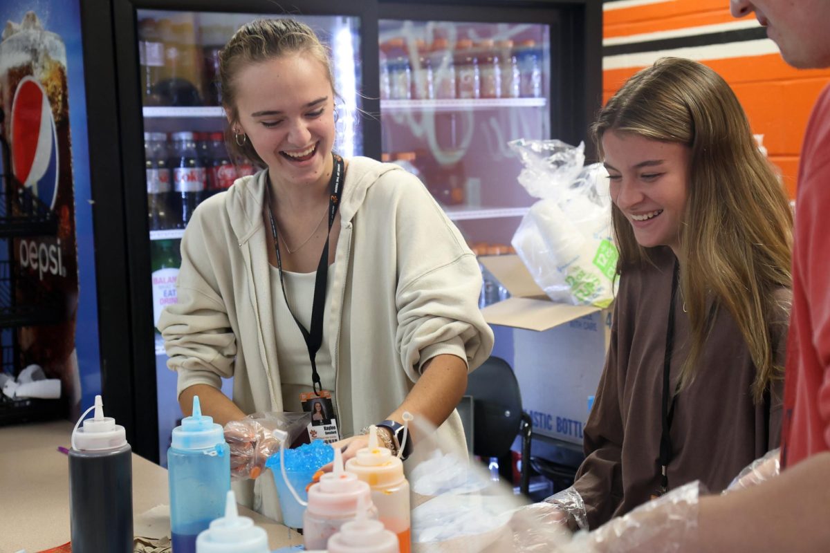 Gessford and senior Grace Lovell work the snow cone stand during A lunch Oct. 29. "Working in the snow cones stands can be hectic and fast-paced, but overall, I enjoy it because I get to interact with many people," Gessford said.