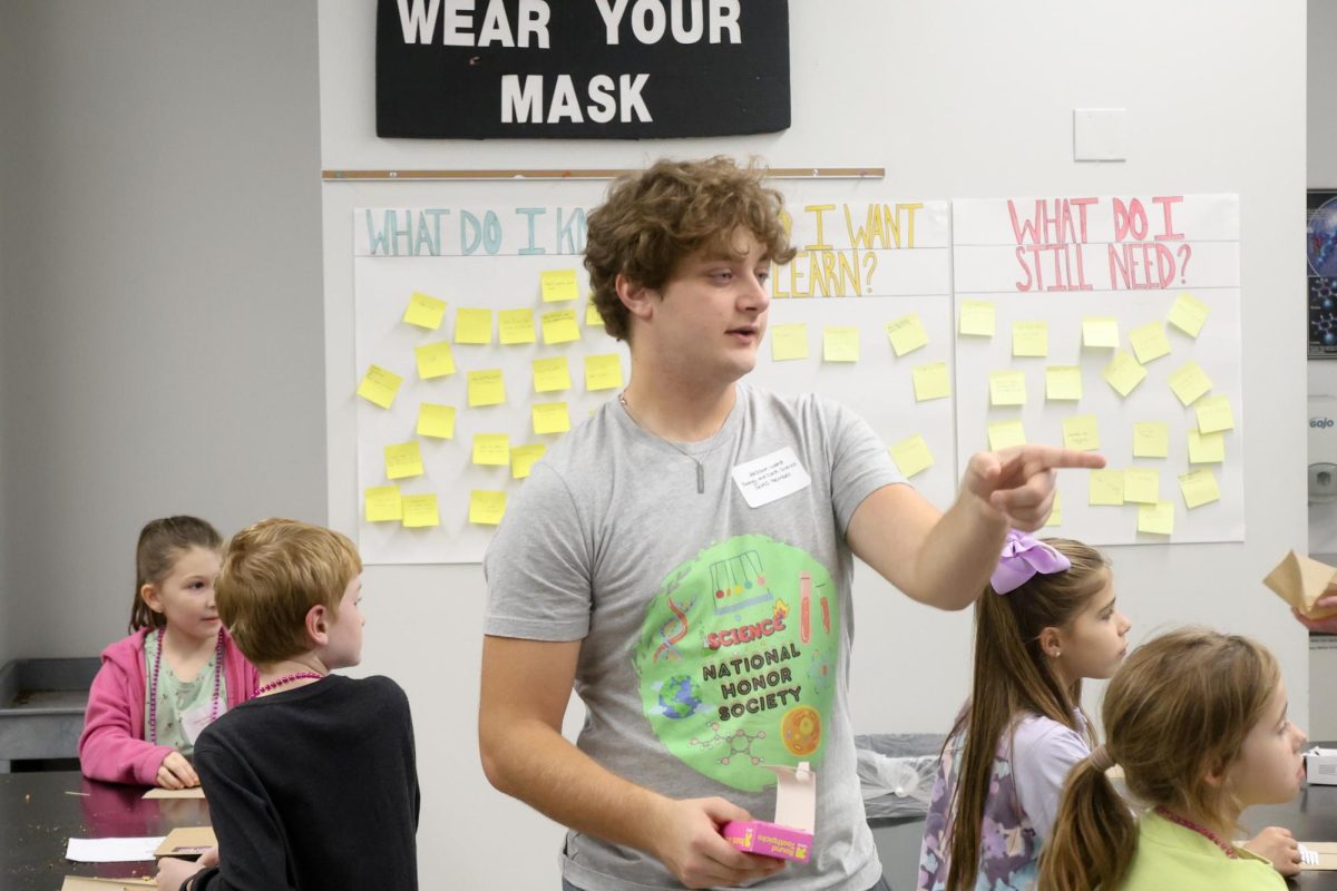 Senior Jackson Ward leads children through a cookie "mining" activity at Science pHun Night Nov. 15.