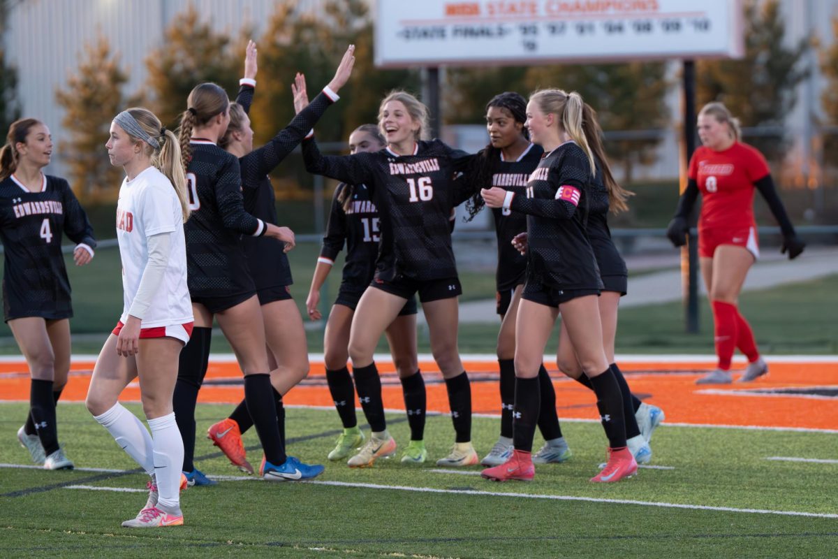 The girls soccer team celebrates after junior Gabby Thompson scored their inaugural goal of the season against Triad March 20.